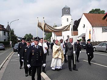 Viele Christen beteiligten sich an der Prozession in Küps. Das Allerheiligste, getragen vom Pater Maximilian Kray, wurde von der Feuerwehr Küps begleitet. Foto: Dieter Wolf