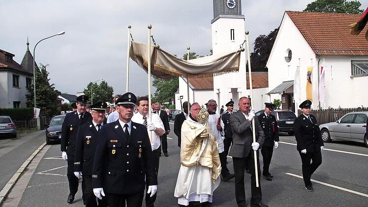 Viele Christen beteiligten sich an der Prozession in Küps. Das Allerheiligste, getragen vom Pater Maximilian Kray, wurde von der Feuerwehr Küps begleitet. Foto: Dieter Wolf