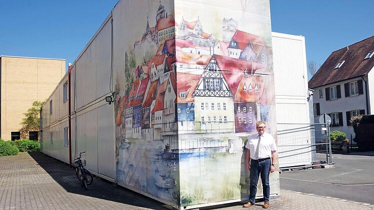 Schulleiter Rudi Schirmer freut sich über die gelungene Fassadenverkleidung der Bürocontainer mit dem dreigliedrigen Kronacher Stadtaufbau. Foto: Heike Schülein