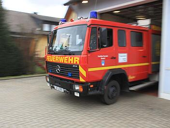 Tim Hallermeier fährt das Feuerwehrauto zur Demonstration aus der Halle. Dabei wird der Schlauch, der an einer Schiene hängt, bis zum Ausgang mitgezogen. Dann wird durch einen Kontaktschalter an der Decke die Druckluft aus der Manschette entlassen, sie rutscht vom Auspuff. Foto: Tobias Kindermann