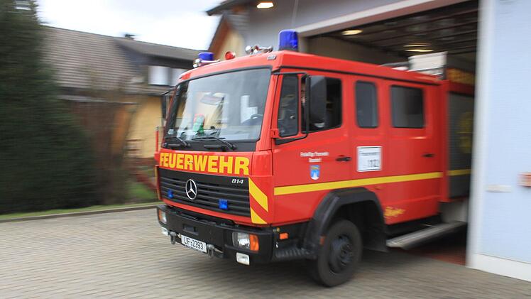 Tim Hallermeier fährt das Feuerwehrauto zur Demonstration aus der Halle. Dabei wird der Schlauch, der an einer Schiene hängt, bis zum Ausgang mitgezogen. Dann wird durch einen Kontaktschalter an der Decke die Druckluft aus der Manschette entlassen, sie rutscht vom Auspuff. Foto: Tobias Kindermann