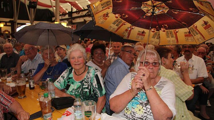 Das Zelt ist nicht ganz dicht - mussten einige Bierfestbesucher feststellen. Doch den Spaß ließen sie sich davon nicht verderben und spannten einfach an den Tischen die Schirme auf. Foto: Sonja Adam