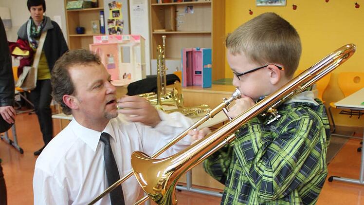 Schulleiter Wojciech Grabietz weist ein Kind an der Posaune ein. Foto: fra-press