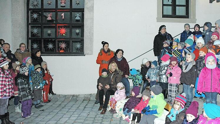 Viele Haßfurter machen beim begehbaren Adventskalender mit. Unser Bild aus dem vergangenen Jahr zeigt die Buben und Mädchen aus der evangelischen Kindertagesstätte vor dem Adventsfenster der Stadthalle. Es öffnete sich für sie und weitere Besucher.  Foto: Ulrike Langer/Archiv
