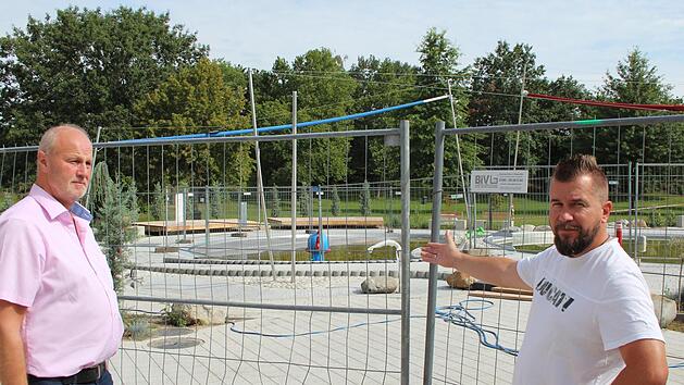 Den Bauzaun um die neuen Kinderbecken m&uuml;ssen Gerald Brehm (links) und Karl-Heinz Zillich noch stehen lassen. Foto: Andreas Dorsch