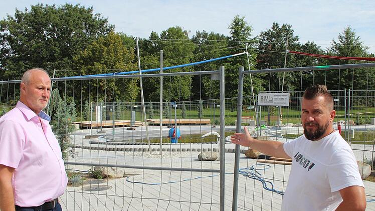Den Bauzaun um die neuen Kinderbecken müssen Gerald Brehm (links) und Karl-Heinz Zillich noch stehen lassen. Foto: Andreas Dorsch