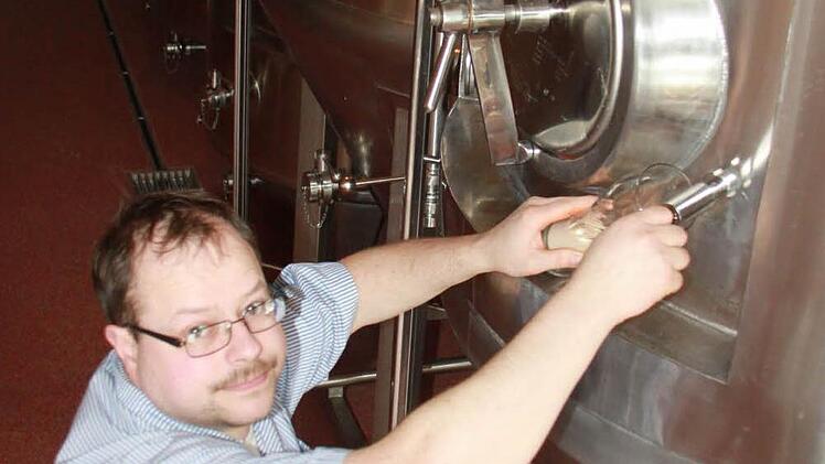Manfred Reichert überprüft beim ,Zwickeln' den naturtrüben Gerstensaft am Gärtank. Dabei untersucht er, wie weit das Bier entwickelt ist.
