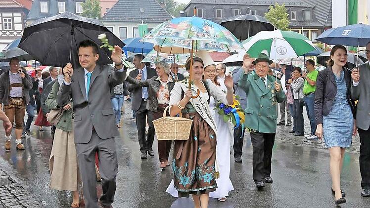 Gewappnet gegen das Nass: die Ehrengäste beim Festumzug. Vorne, von links, Bürgermeister Andreas Hügerich und Korbstadtkönigin Helena I.