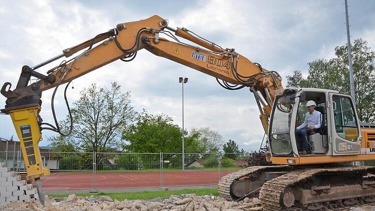 Bürgermeister Marco Steiner nimmt mit dem Abbruchbagger den symbolischen ersten "Spatenstich" vor. Foto: Rainer Lutz