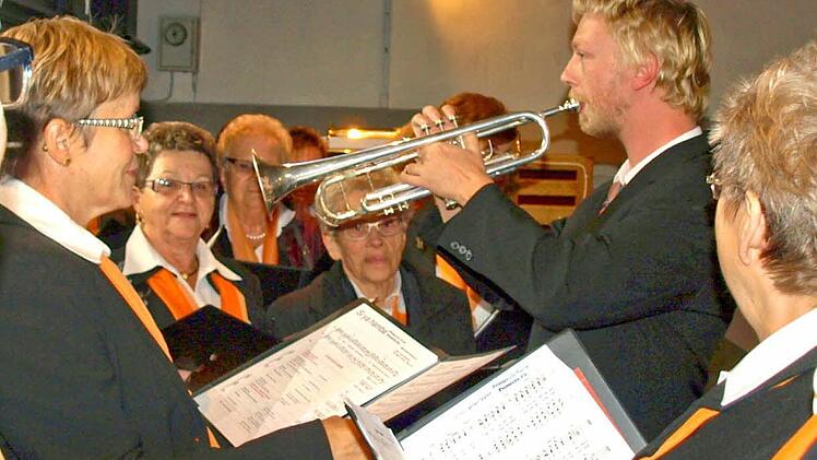 Stefan Reuther dirigiert auf der Empore mit der Trompete den Frauenchor der Chorgemeinschaft Steinwiesen-Nurn beim "Vater unser".  Foto: Susanne Deuerling