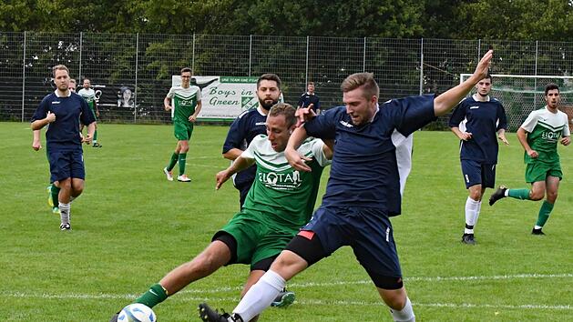 Die Gr&uuml;nen in blauen Trikots: Farblich im ungewohnten Outfit trat der SV Garitz um David Schlereth (vorne, im Zweikampf mit Mike Ludewig) zum Heimspiel gegen die SG Hammelburg/Fuchsstadt II. Zum Sieg reichte es dennoch. Foto: Hopf