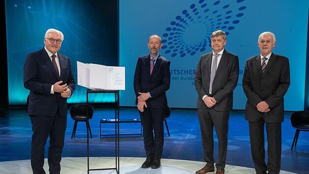 Professor Thorsten Gerdes von der Uni Bayreuth (Zweiter von links),  Friedbert Scharfe (Zweiter von rechts), der Entwicklungsleiter beim Azendorfer Baustoffhersteller  Maxit ist, sowie   Klaus Hintzer (rechts) vom  globalen Technologiekonzern Dyneon/3M haben den innovativen D&auml;mmstoff entwickelt. Bundespr&auml;sident Frank-Walter Steinmeier zeigte sich beeindruckt.  Foto: ZDF/Oliver Ziebe,