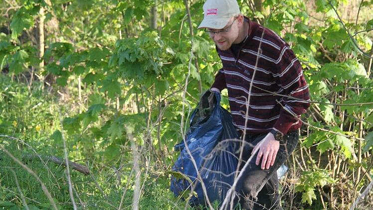 Stephan Seifert von der Jungen Union kämpft sich durchs Dickicht und sammelt Plastikmüll und anderen Unrat .