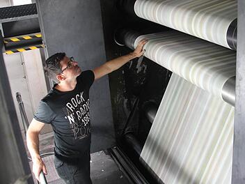 Behutsam fühlt Christian Vitzthum die Qualität des mit 55 Kilometern pro Stunde vorbeirauschenden Papiers. Foto: Daniel Ruppert