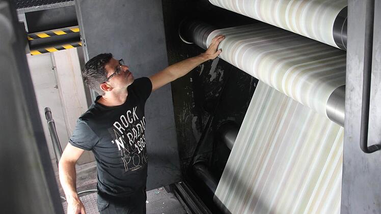 Behutsam fühlt Christian Vitzthum die Qualität des mit 55 Kilometern pro Stunde vorbeirauschenden Papiers. Foto: Daniel Ruppert