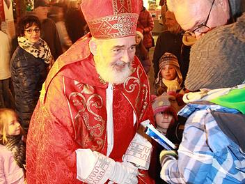 Nikolaus-Darsteller Udo Dickhage verteilt beim Weihnachtsmarkt am Freitagabend Schokolade an die Kinder. Foto: Carmen Schmitt