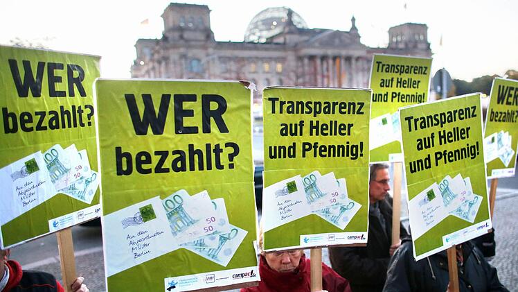 Aktivisten demonstrieren am 18.10.2012 in Berlin vor dem Reichstag für mehr Transparenz bei den Nebeneinkünften von Bundestagsabgeordneten. Zuvor wurden 60000 Unterschriften von Bürgern an Bundestagsabgeordnete übergeben. Foto: Kay Nietfeld/dpa