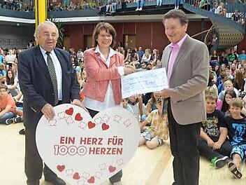 Voller Freude überreicht Schulleiterin Christa Bänisch im Namen aller Schüler einen Scheck über 500 Euro an Gerhard Burkert-Mazur (rechts). Mit im Bild: Heinz Hausmann (Verteilerausschuss 1000 Herzen für Kronach) Foto: Karl-Heinz Hofmann