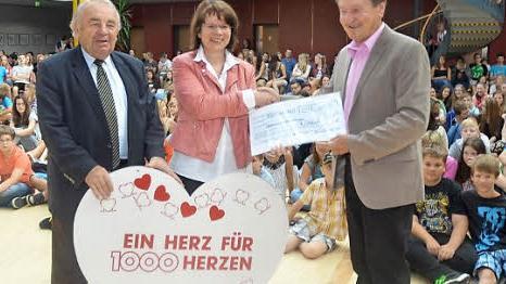 Voller Freude überreicht Schulleiterin Christa Bänisch im Namen aller Schüler einen Scheck über 500 Euro an Gerhard Burkert-Mazur (rechts). Mit im Bild: Heinz Hausmann (Verteilerausschuss 1000 Herzen für Kronach) Foto: Karl-Heinz Hofmann