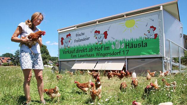 "Unsere Hennen hei&szlig;en alle Helga": Ursula Lauerhaas in Mitten ihrer t&auml;glichen Eierlieferanten. Der mobile H&uuml;hnerstall wird alle zwei Wochen versetzt, damit die Hennen immer auf frischen Wiesen scharren k&ouml;nnen. Fenster und Zug&auml;nge &ouml;ffnen sich automatisch.  Fotos: Sebastian Schanz
