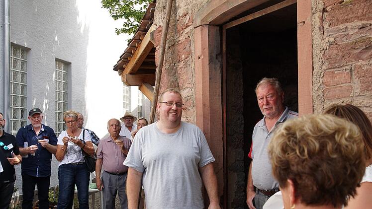 Michael Stöth (Mitte) empfängt   am Dorfbackhaus. Er hat für die Gruppe Plootz gebacken.Foto: Arkadius Guzy