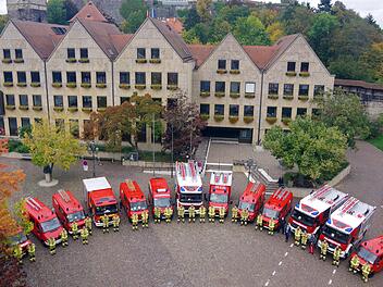 Die Kommandanten und deren Stellvertreter von den Feuerwehren aus dem Kronacher Stadtgebiet freuten sich bei der Übergabe durch Bürgermeisterin Angela Hofmann vor dem Rathaus über die neuen Schutzanzüge. Foto: Heike Schülein