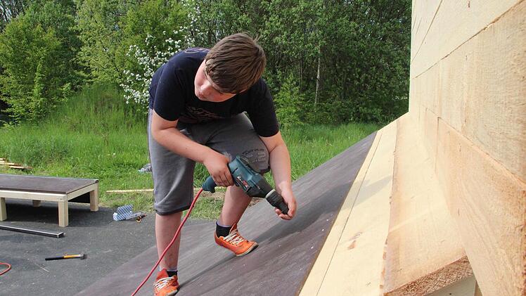 Justin Reising schraubt die Siebdruckplatten fest, damit er bald mit seinem BMX darauf fahren kann.