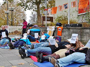 Pflege am Boden: Ein Dutzend Pflegekräfte aus den Landkreisen Bad Kissingen und Rhön-Grabfeld legten sich stellvertretend für alle Kollegen auf den kalten Boden. Fotos: Sigismund von Dobschütz