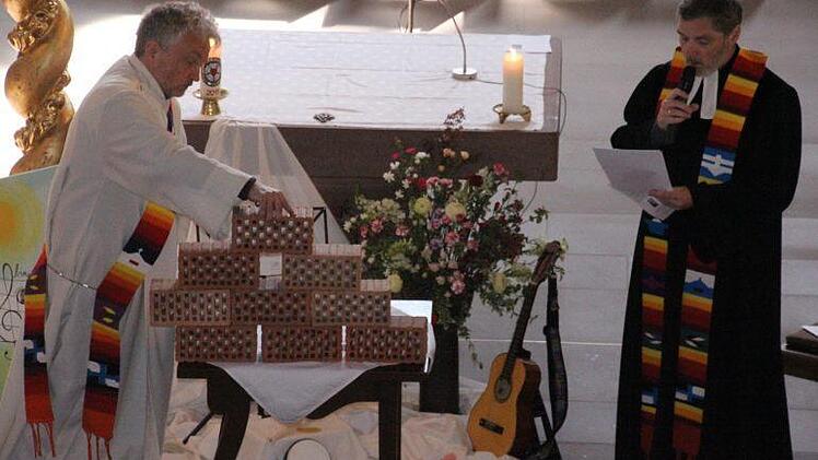 Anschaulich stellten im ökumenischen Gottesdienst Diakon Uwe Holzschuh und Pfarrer Bernd Grosser (von links) dar, dass Mauern trennen aber auch Schutz bieten können. Foto: Helmut Will