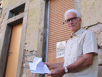 Hartmut Hessel steht vor dem Reißmannshaus. In den Händen hält er ein Modell des Anwesens, wie es nach der Restaurierung aussehen soll. Foto: Heike Beudert