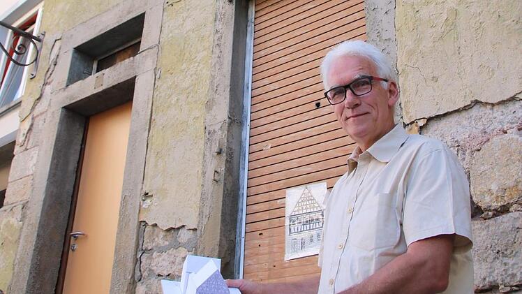 Hartmut Hessel steht vor dem Reißmannshaus. In den Händen hält er ein Modell des Anwesens, wie es nach der Restaurierung aussehen soll. Foto: Heike Beudert