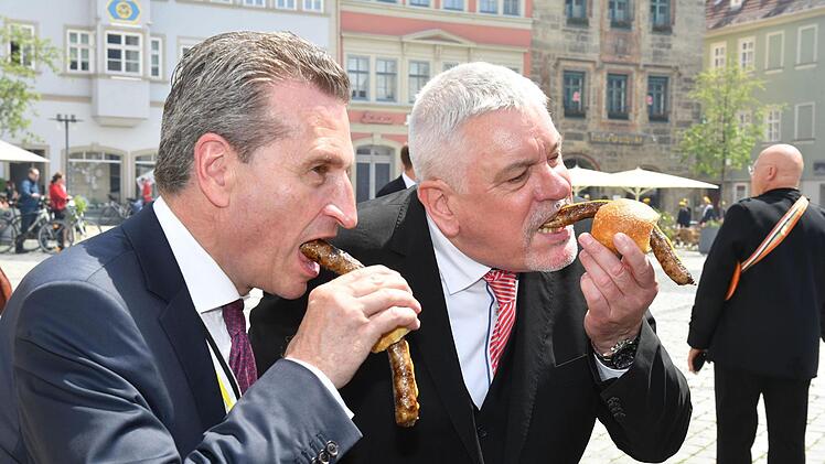 EU-Kommissar Günther Oettinger (links) und OB Norbert Tessmer beim Bratwurstessen für Fortgeschrittene: leicht nach vorn gebeugt, damit Fett und Senf nicht auf die Krawatte tropfen. Foto: Ronald Rinklef