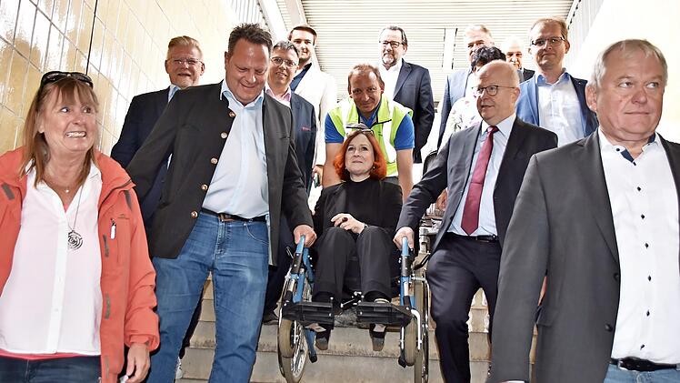 Die Senioren- und Behindertenbeauftragte Christina Flauder machte den Test und ließ sich in einem Rollstuhl von Michael Theurer (rechts) und Ingo Lehmann (links) die Bahnhofstreppe hinuntertragen.