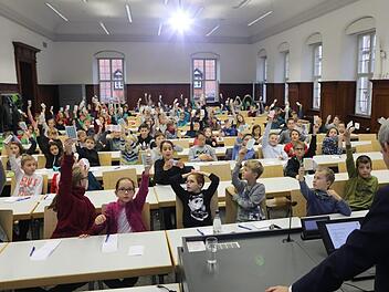 Mit gelben, grünen und roten Karten stimmten die Kinder-Uni-Besucher ab, welche Spielzüge Christoph Schlieder (vorne) gegen den Computer machen sollte.