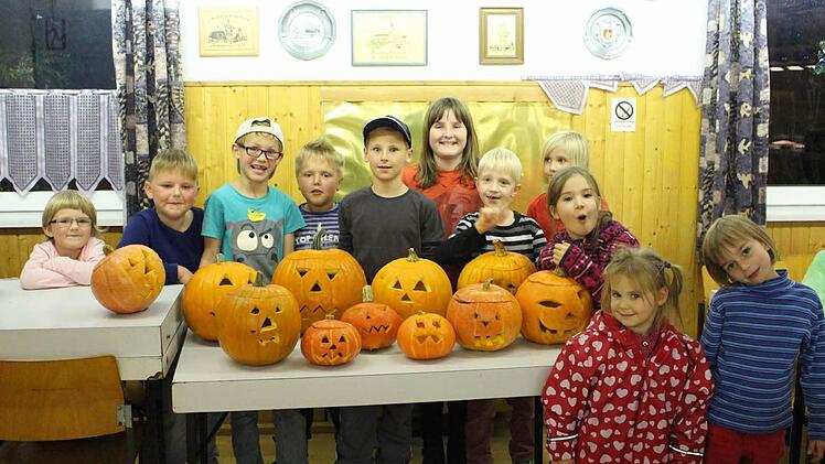 Stolz präsentieren die Jungs und Mädels der Kinderfeuerwehr Neubrunn ihre fertigen Kürbisgesichter. Foto: Janina Reuter