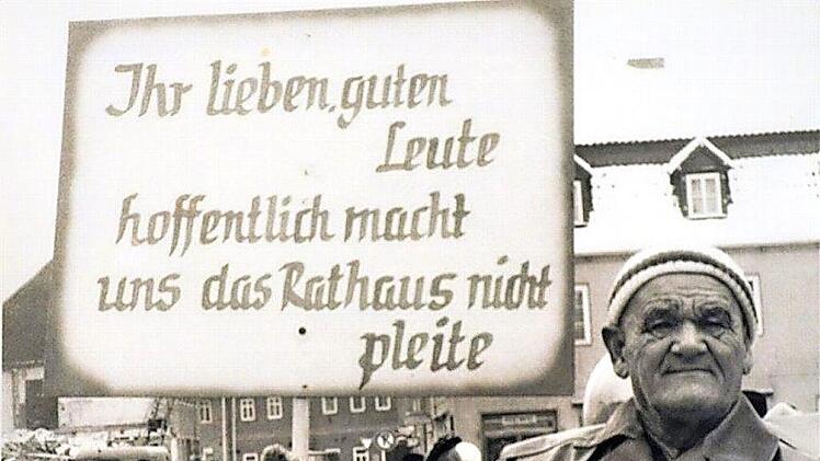 Mit einem Spruchschild machte am Faschingsdienstag 1969 Dachdecker Paul Wege auf die hohen Kosten für den Rathausneubau aufmerksam.