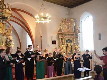 Der Kammerchor Wernigerode mit seinem Dirigenten Rainer Fiala (r.) begeisterte die Zuhörer in der St. Nikolaus- Kirche in Windheim. Ein aufmerksamer Zuhörer war das Gründungsmitglied des Chores und heutiger Dirigent des Windheimer Männerchores, Markus Häßler (sitzend) mit Kontakt zu Chor und Dirigent. Foto: K.- H. Hofmann