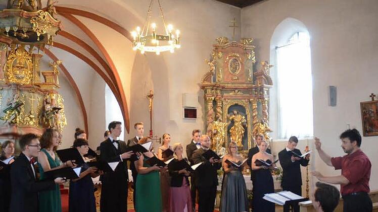 Der Kammerchor Wernigerode mit seinem Dirigenten Rainer Fiala (r.) begeisterte die Zuhörer in der St. Nikolaus- Kirche in Windheim. Ein aufmerksamer Zuhörer war das Gründungsmitglied des Chores und heutiger Dirigent des Windheimer Männerchores, Markus Häßler (sitzend) mit Kontakt zu Chor und Dirigent. Foto: K.- H. Hofmann