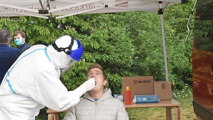 Sebastian D&uuml;ck vom Landratsamt Kulmbach f&uuml;hrt vor, wie der Abstrichtest unter dem Zeltdach des roten Campingwagens durchgef&uuml;hrt wird.  Foto: Uschi Prawitz