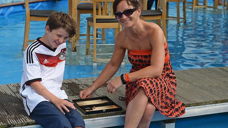 Josper und seine Mutter Simone spielen am Wasser Backgammon. Foto: Nikolas Pelke