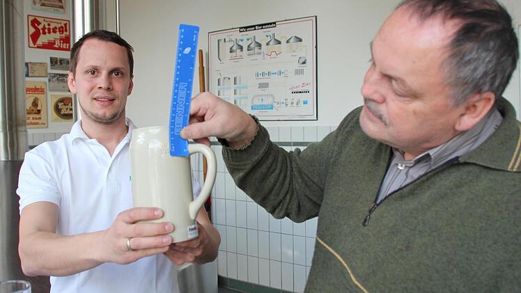 Hans-Günter und Benno Wirth (von links) verweisen auf den Eichstrich, der jetzt vier Zentimeter unter dem oberen Rand liegt. Foto: Andreas Dorsch