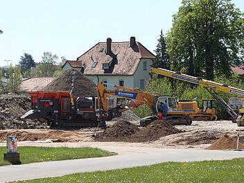 Die mobile Bauschuttrecycling-Anlage auf dem Festplatz in den Aischwiesen ist den Bewohnern des Hauses (im Hintergrund) ein Dorn im Auge. Foto: Andreas Dorsch