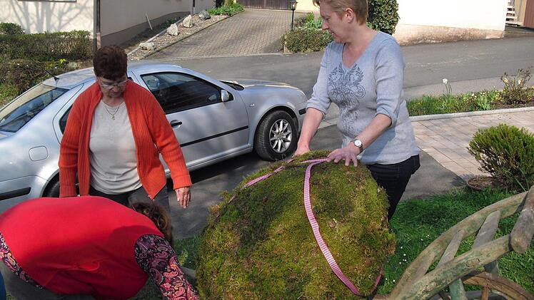 Zum Schluss wird der Osterbrunnen geschmückt. Foto: Helmut Klösel