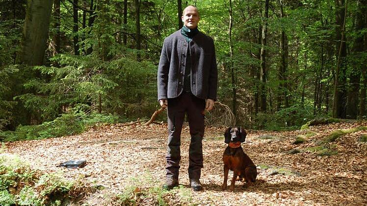 Fabian Hecker mit seinem Rüden Gino an einem Weiher im Seßlacher Gehrenholz. Foto: Rainer Lutz
