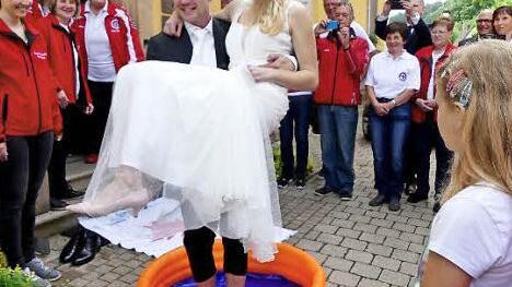 Michael und Eva-Maria Hartmann werden nach ihrer Trauung von den Aktiven der Wasserwacht und des Tennisclubs begrüßt. Foto: Dieter Hübner