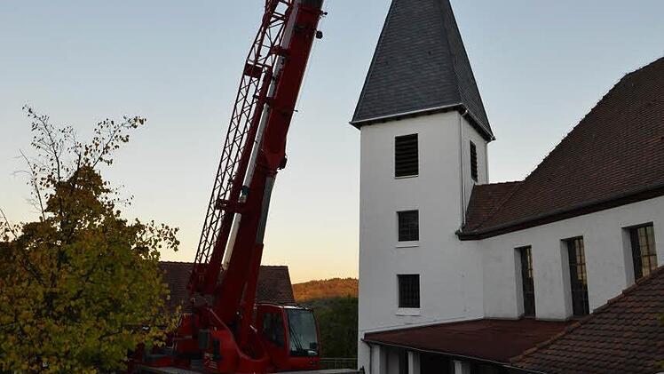 Kupferkugel und Wetterhahn - jeweils frisch vergoldet - werden montiert.  Foto: Alexander Rosenmeyer