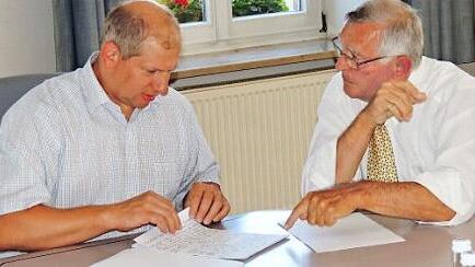 Bürgermeister Klaus Faatz und Autor Hermann Meißner im Gedankenaustausch über die Dokumentation "Post in "Mühlhausen  Foto: Dieter Gropp
