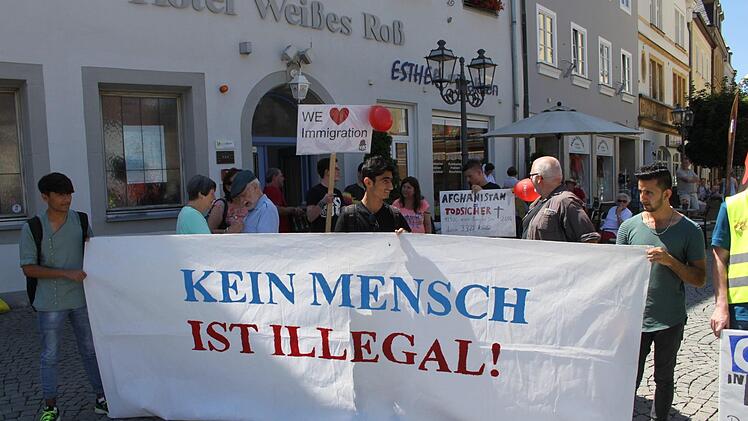 "Kein Mensch ist illegal". So lautet der Schriftzug eines Plakats, das junge Afghanen hoch halten.