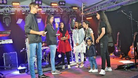 Lukas Beetz und Julia Geiger (von links) führten Interviews mit einigen Schülern und Kindern aus verschiedenen Herkunftsländern. Sehr frei und mit sehr gutem Deutsch erzählten sie von ihren Fluchterlebnissen und von guter Aufnahme in Deutschland und besonders in Rothenkirchen.  Foto: K.- H. Hofmann