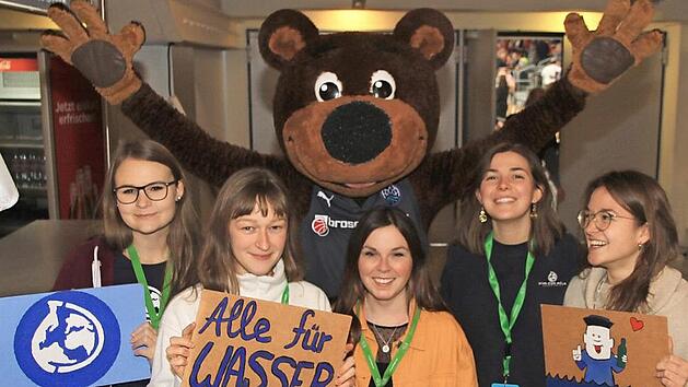 Gute Laune in der Brose-Arena: Zusammen mit dem Maskottchen "Freaky" (Hintergrund) freut sich die Ansprechpartnerin von "Viva con Agua", Sophie Luther (Zweite von rechts), mit ihren Sammlerinnen &uuml;ber die gute Resonanz bei den Basketball-Heimspielen.  Foto: Bertram Wagner